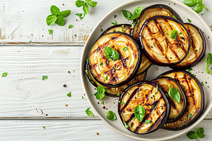 Slices of grilled eggplants in plate on wooden table, a Food & Drink Photo by AlyaAnd
