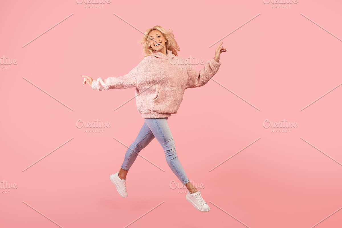 Joyful stylish woman running and jumping, posing in mid-air over pink studio ba, a Photo by Prostock-Studio (Photo 1 of 3)