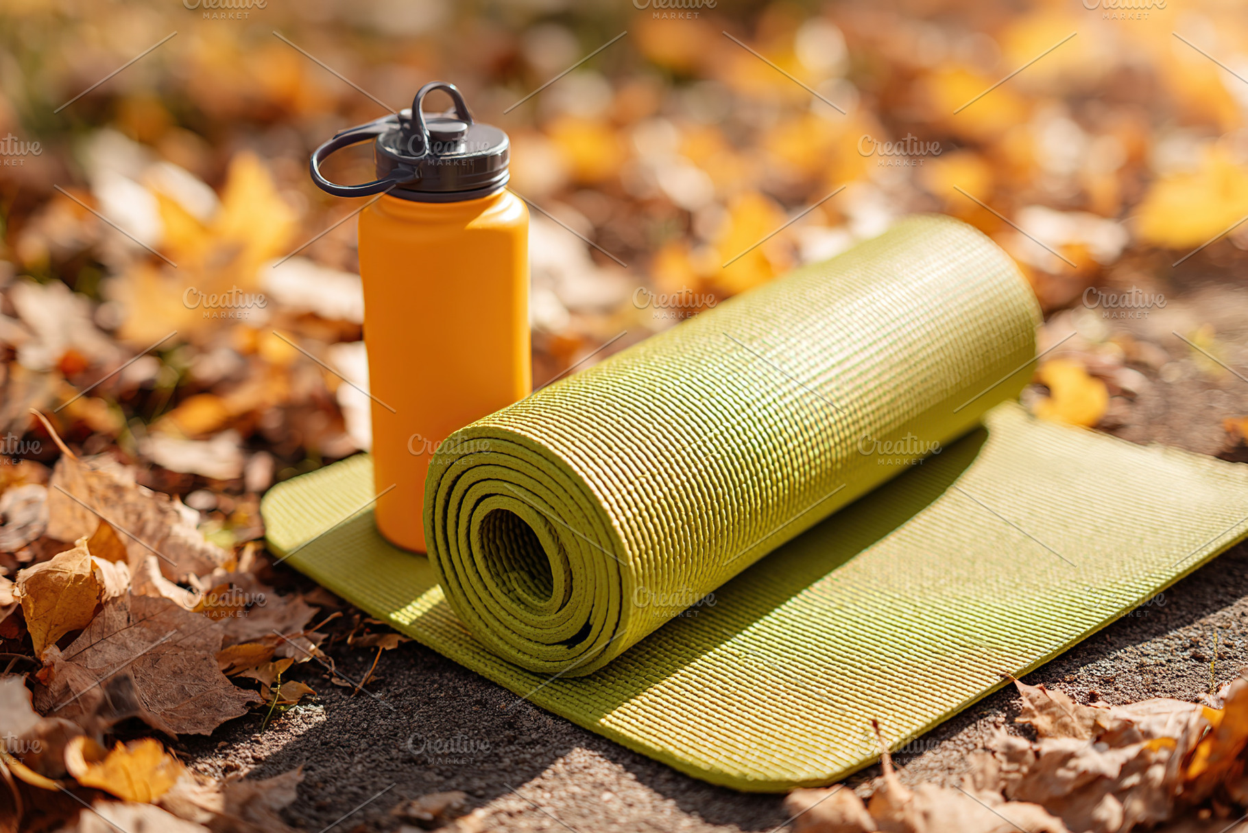 Yoga mat and water bottle amidst golden autumn leaves in the park during a peac, a Photo by AlyaAnd