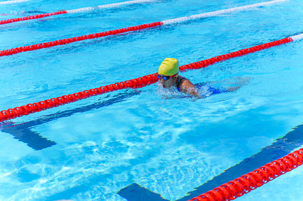 Swimmer child swims breaststroke swimming style in a race swimmi