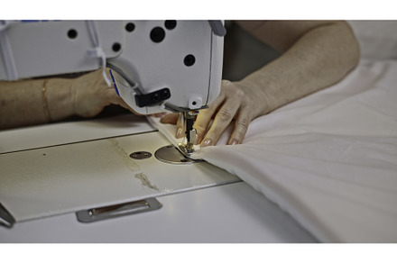 Close up of seamstress sewing white, an Industrial Photo by Media Whale Stock