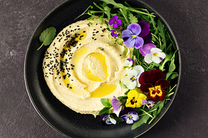 Gourmet Hummus with Edible Flowers and Olive Oil on Dark Backgro, a Food & Drink Photo by Natalia Klenova's Shop