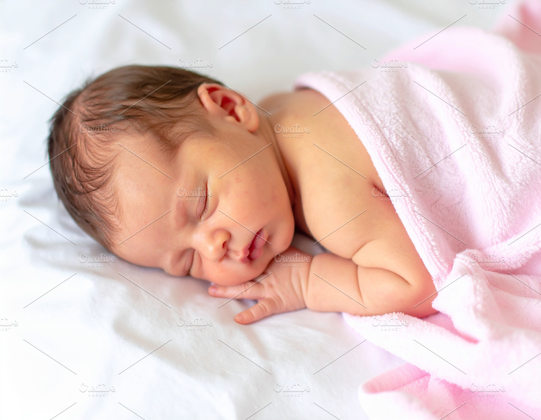 Photo of a newborn baby sleeping peacefully on a white bed, wrap, a Person Photo by DanFLCreativo