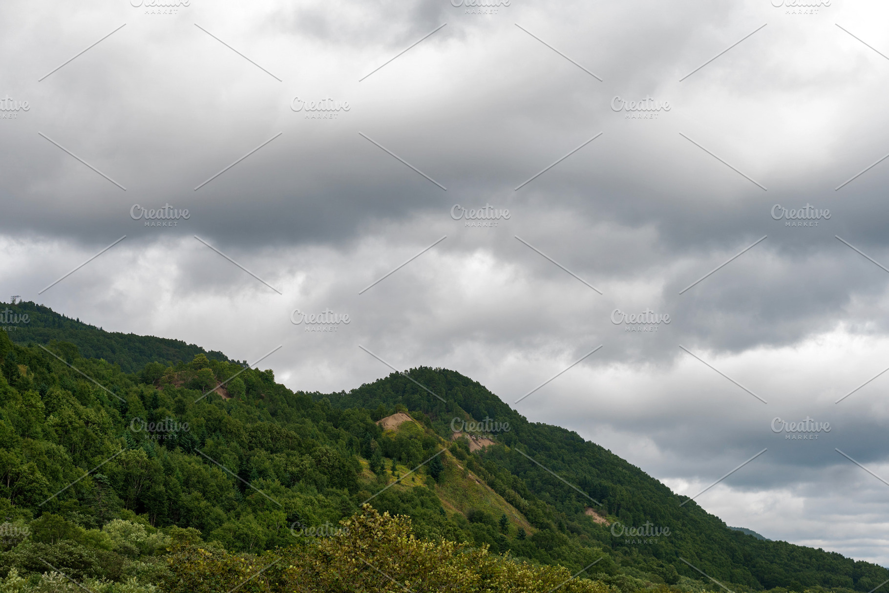 Forested mountain slope beneath over, a Nature Photo by Elena Vagengeim