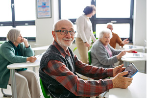 Senior man learning digital skills, a Technology Photo by HalfPoint