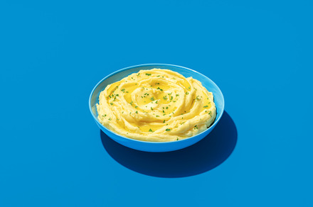 Mashed potatoes bowl minimalist on a blue background, a Food & Drink Photo by YesPhotographers