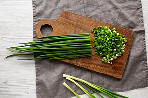 Organic Cut Green Onion Scallions on a Wooden Board, top view., a Food & Drink Photo by LiudmylaChuhunova