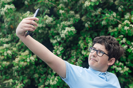 Portrait of eleven years old boy in glasses, making selfie, blossom tree or bus, a Person Photo by iuliia_n