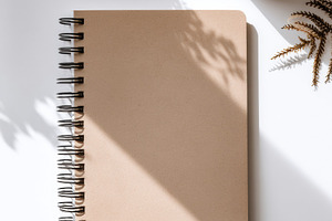 Single brown notebook on white, a Photo by Virgo Studio