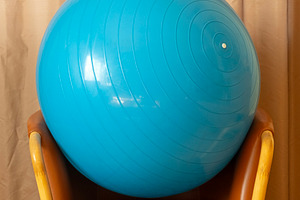 Blue gym ball rests on the armchair, a Sports & Recreation Photo by BOOCYS