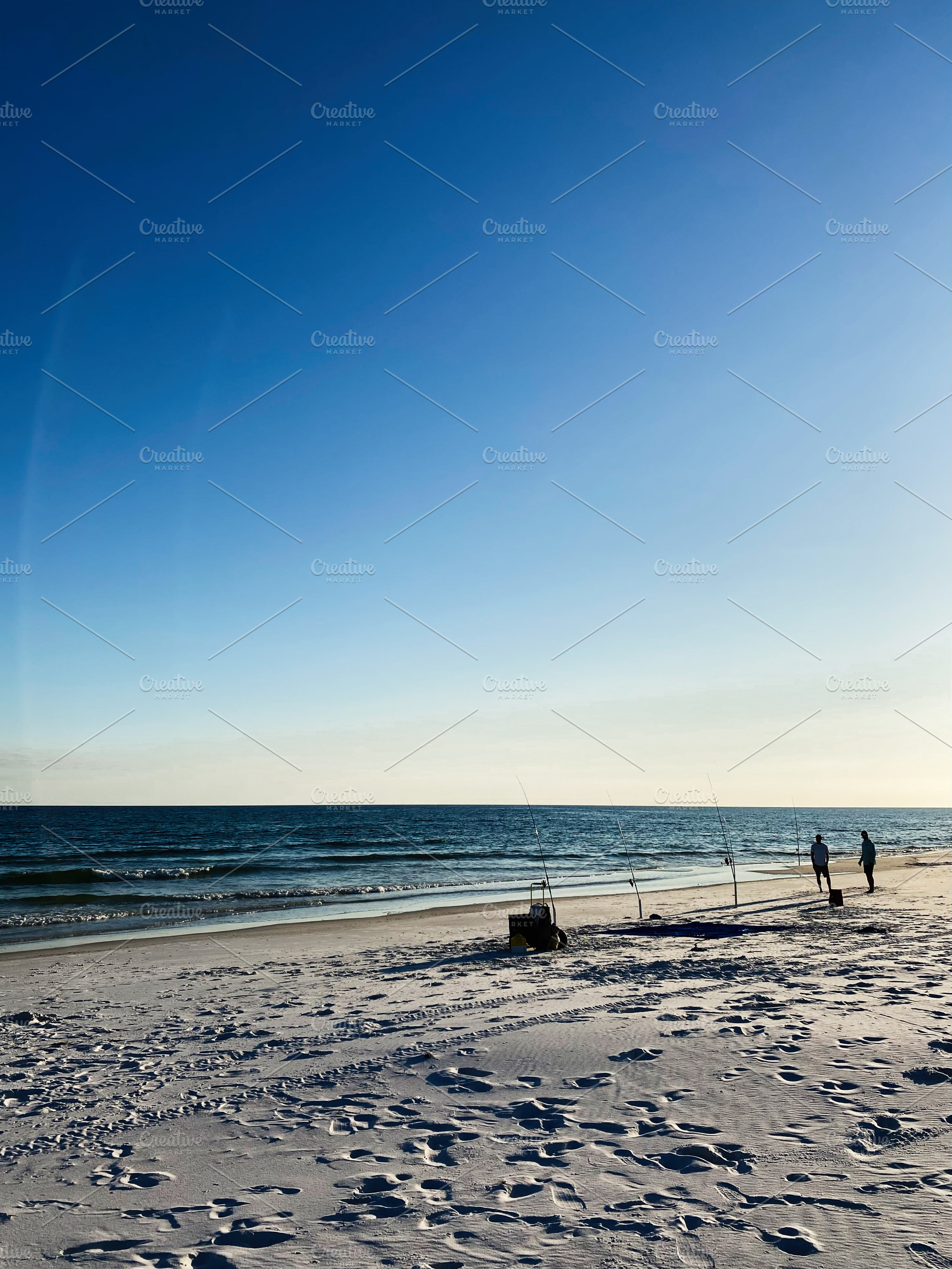 Florida Pensacola beach scene with fishing rods on the sand and silhouettes wal, a Nature Photo by AS photostudio