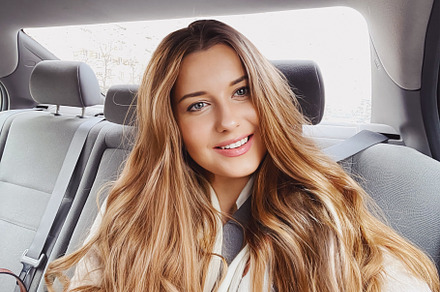 Young woman with long hair, wavy hairstyle in the car or taxi ca, a Person Photo by Anneleven