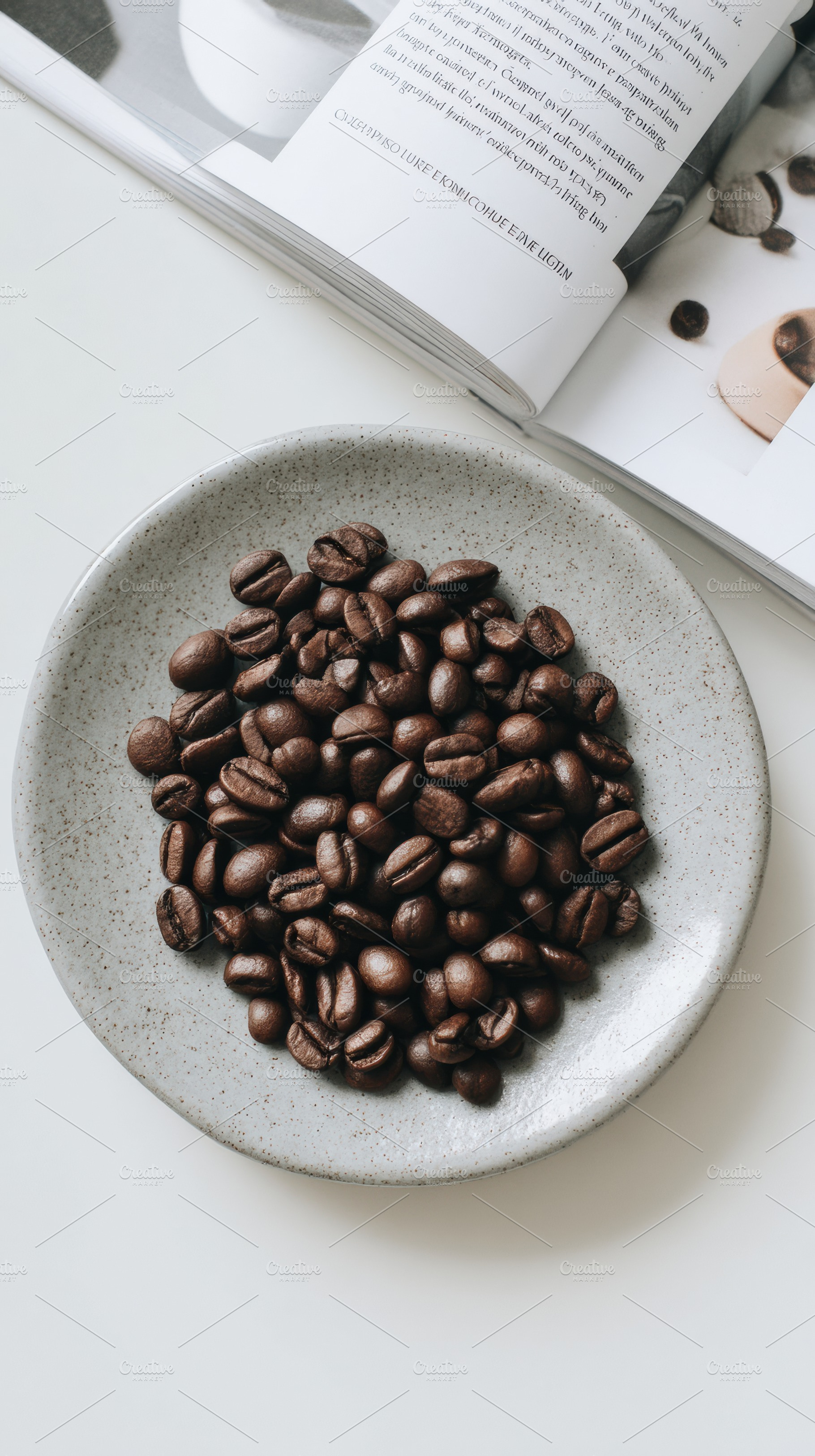 Coffee beans on white plate, a Photo by Virgo Studio