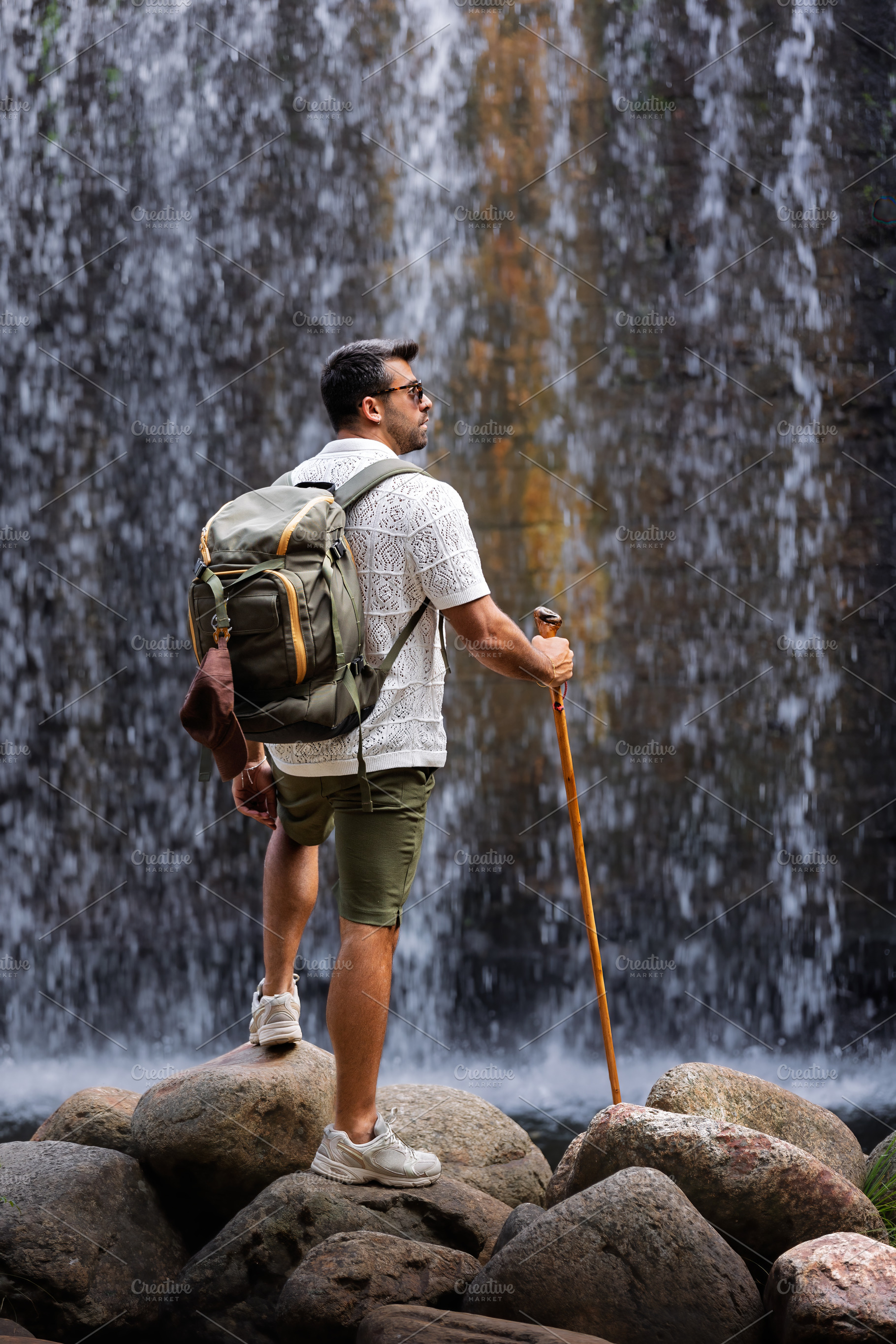 Explorer observing a waterfall from, a Person Photo by Perpis