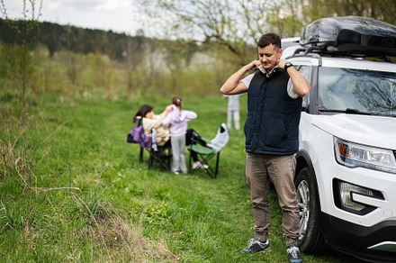 Man in sleeveless vest against suv car with roof rack box, famil, a Person Photo by AS photostudio