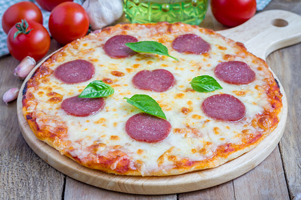 Homemade pepperoni pizza on a wooden board, ready to eat, a Food & Drink Photo by iuliia_n