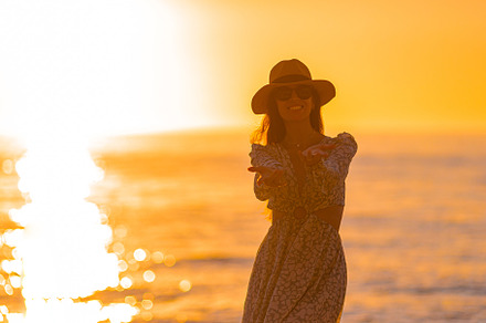 Young beautiful woman at straw hat on the beach at sunset, a Person Photo by travnikovstudio