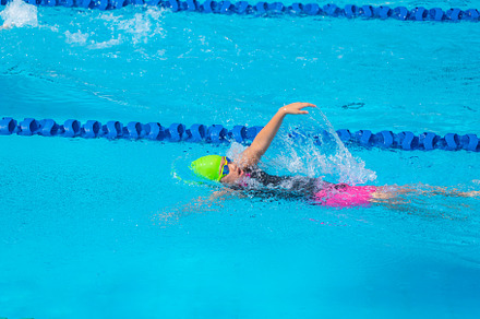 Swimmer child swims backstroke swimming style in a race swimming