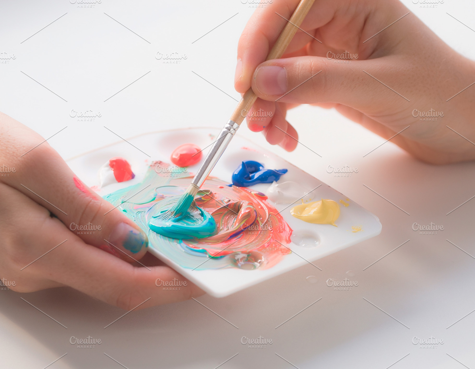 Hands delicately mixing acrylic paint with a brush., an Abstract Photo by DanFLCreativo