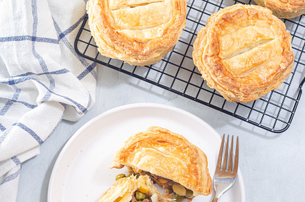 Sliced beef pot pie on plate, pies on cooling rack, vertical, top view, a Food & Drink Photo by iuliia_n
