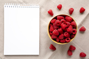Organic Raw Red Raspberries in a Bowl, blank notepad, top view., a Food & Drink Photo by LiudmylaChuhunova