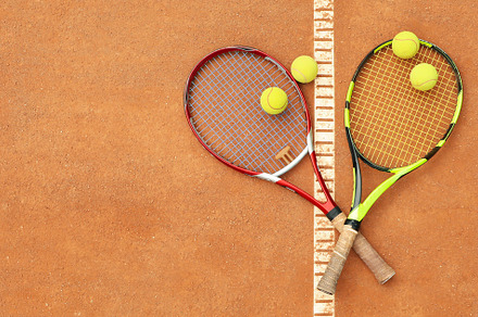 Tennis racquets with tennis balls on clay court