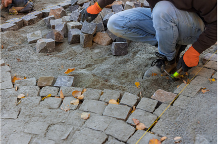 Road master of gloves lays paving, an Industrial Photo by Ungvar Studio