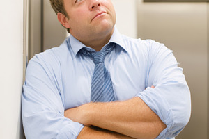 Thoughtful businessman waiting for the elevator, a Person Photo by AlyaAnd