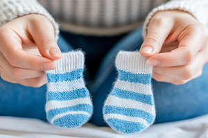 Pregnancy concept hands holding blue, a Photo by Dvoevnore photos