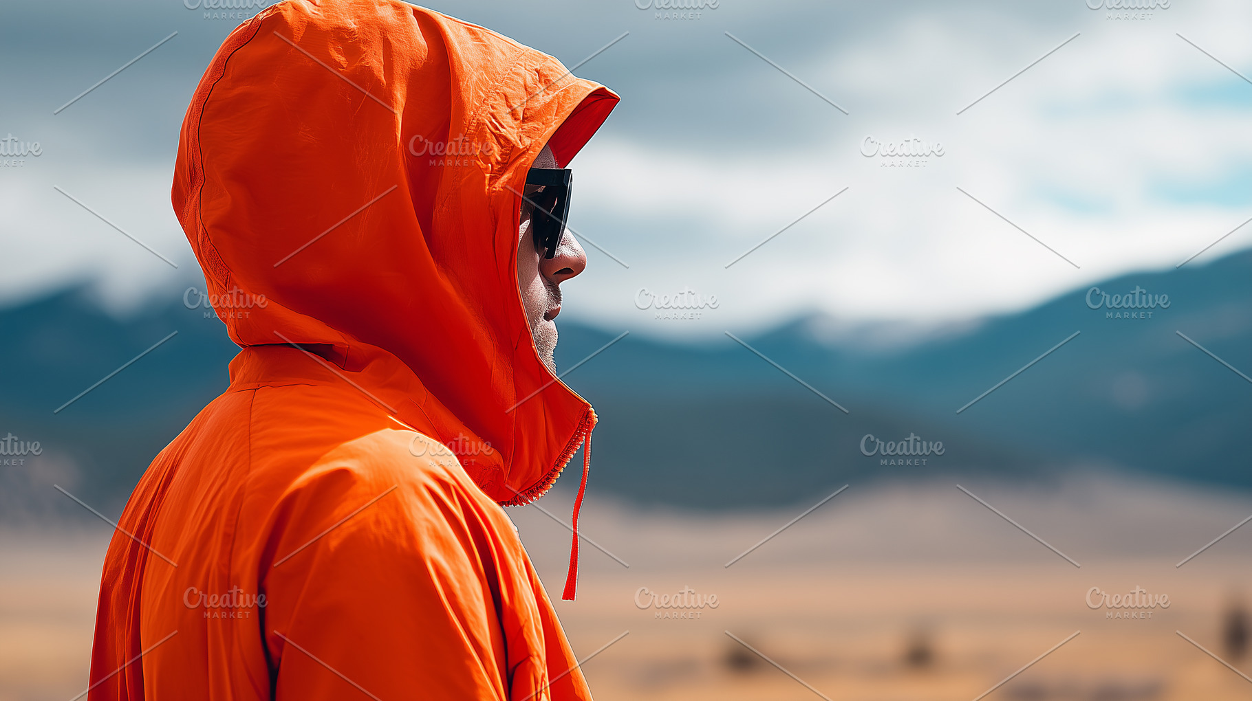 Man in a bright orange hooded jacket, a Person Photo by MistyDay