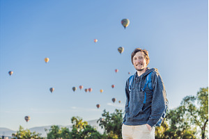 Male tourist standing with colorful, a Holiday Photo by Elizaveta Galitskaya