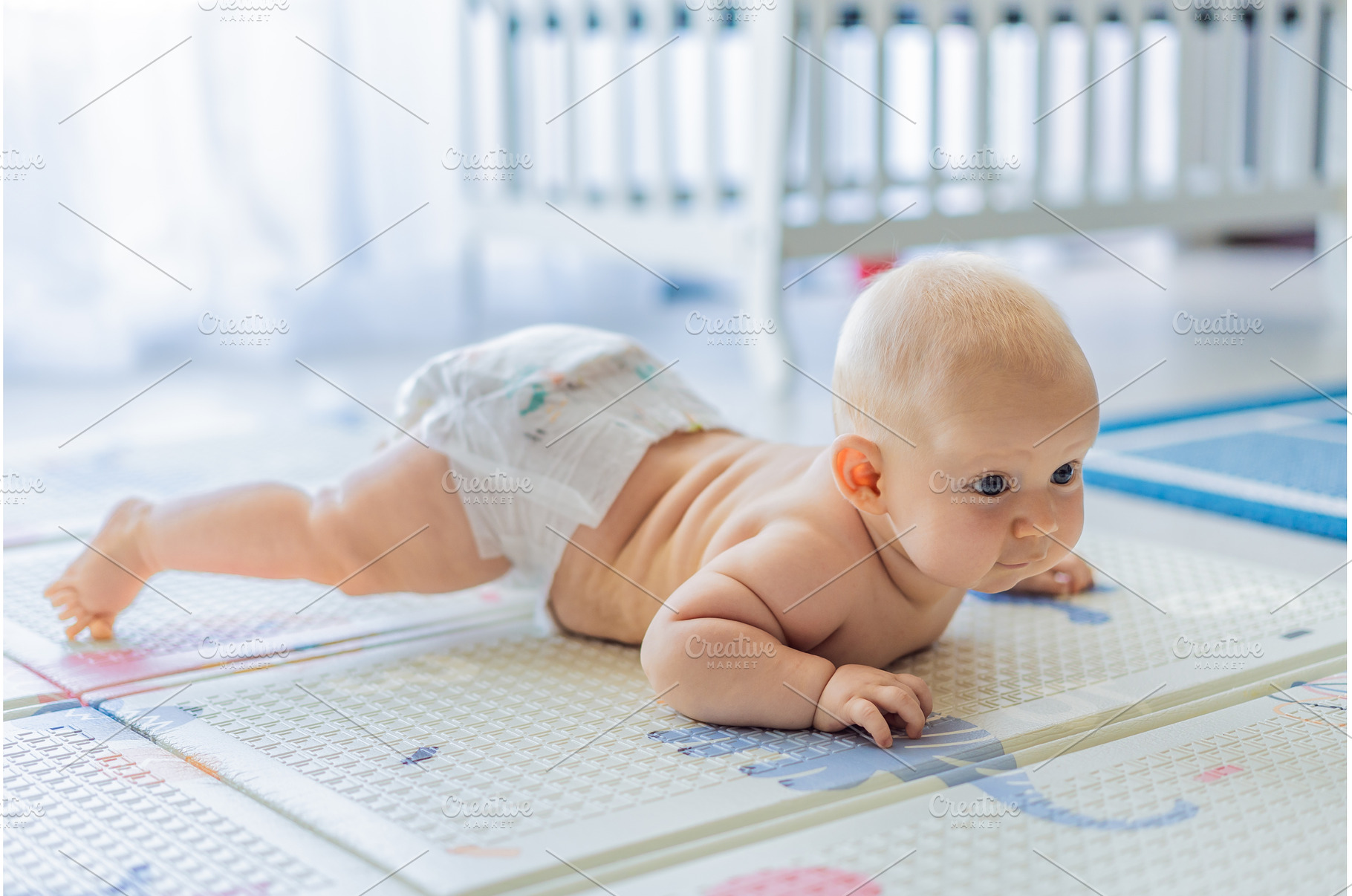 Baby lying on play mat learning to, a Person Photo by Elizaveta Galitskaya