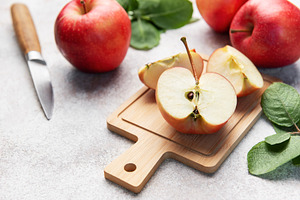 Red apples slicing on cutting board ready for healthy snack, a Food & Drink Photo by Olena Rudo