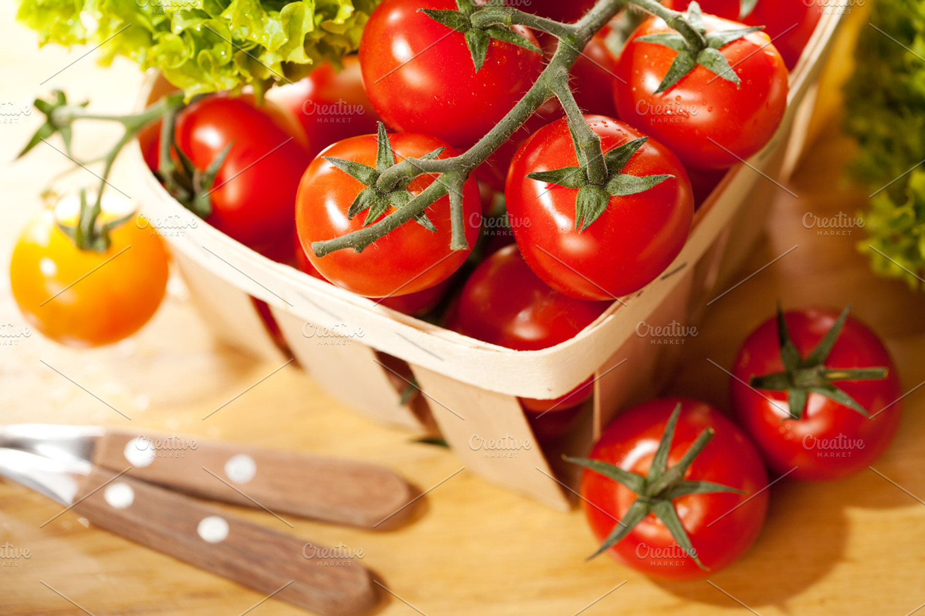 Tomatoes and salad in wooden basket featuring basket, branch, and bright