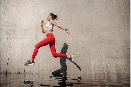 Fitness woman running in front of, a Sports & Recreation Photo by HalfPoint
