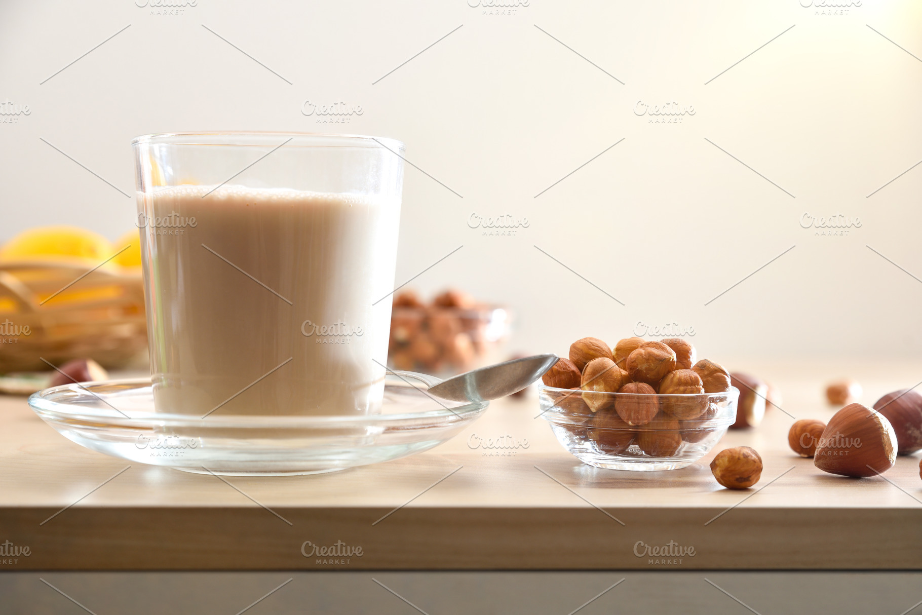 Glass with hazelnut drink and hazelnuts on bench isolated backgr, a Food & Drink Photo by Davizro's Market