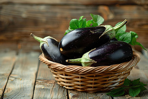 Fresh eggplants in basket on wooden table, a Food & Drink Photo by AlyaAnd