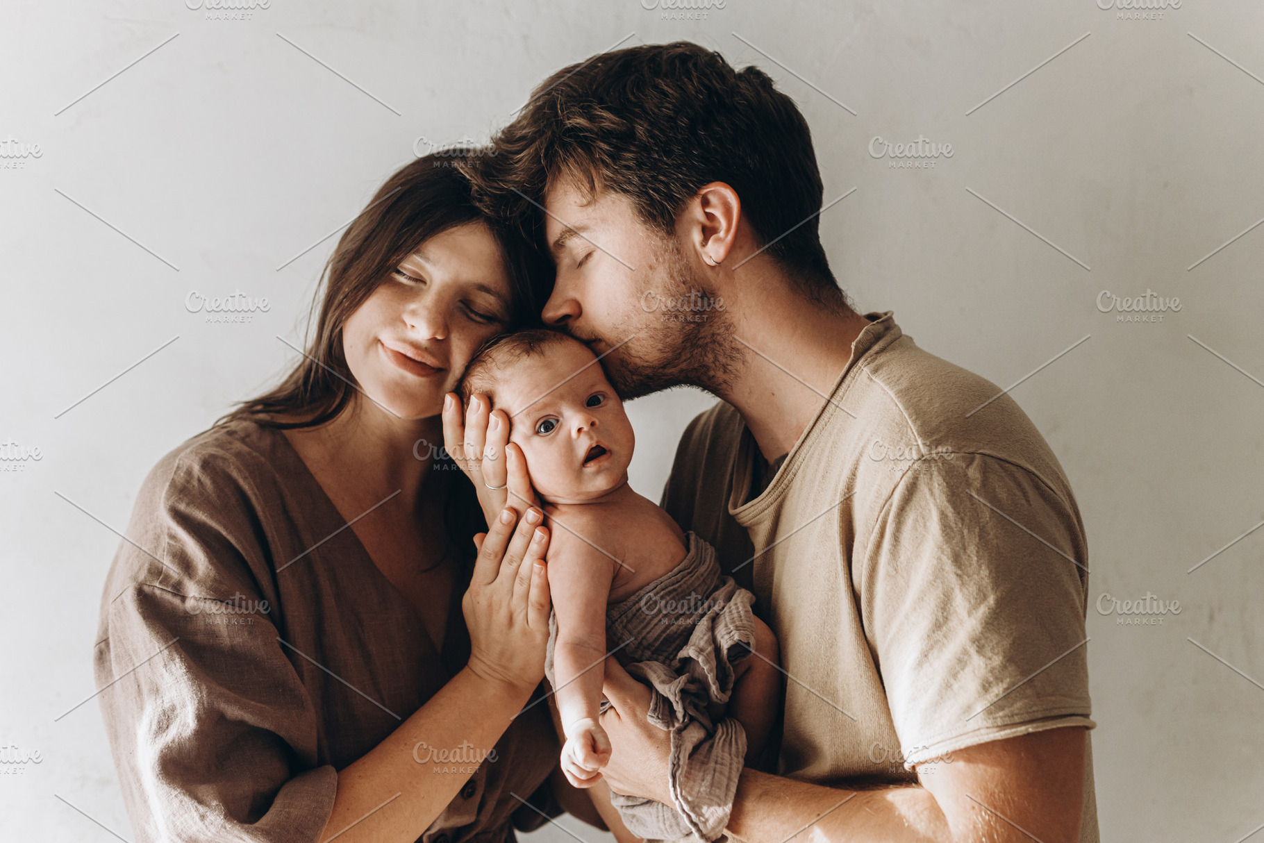 Happy mother and father hugging and kissing little baby son. Hap, a Person Photo by Sonjachni