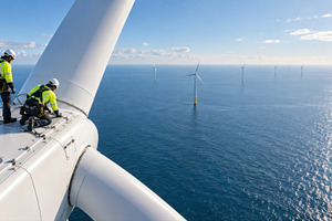 Workers on wind turbine in ocean