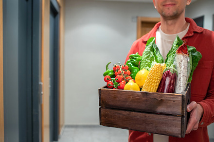Delivery man holding paper bag with food in the entrance. The courier gives the, a Food & Drink Photo by Budarinphoto