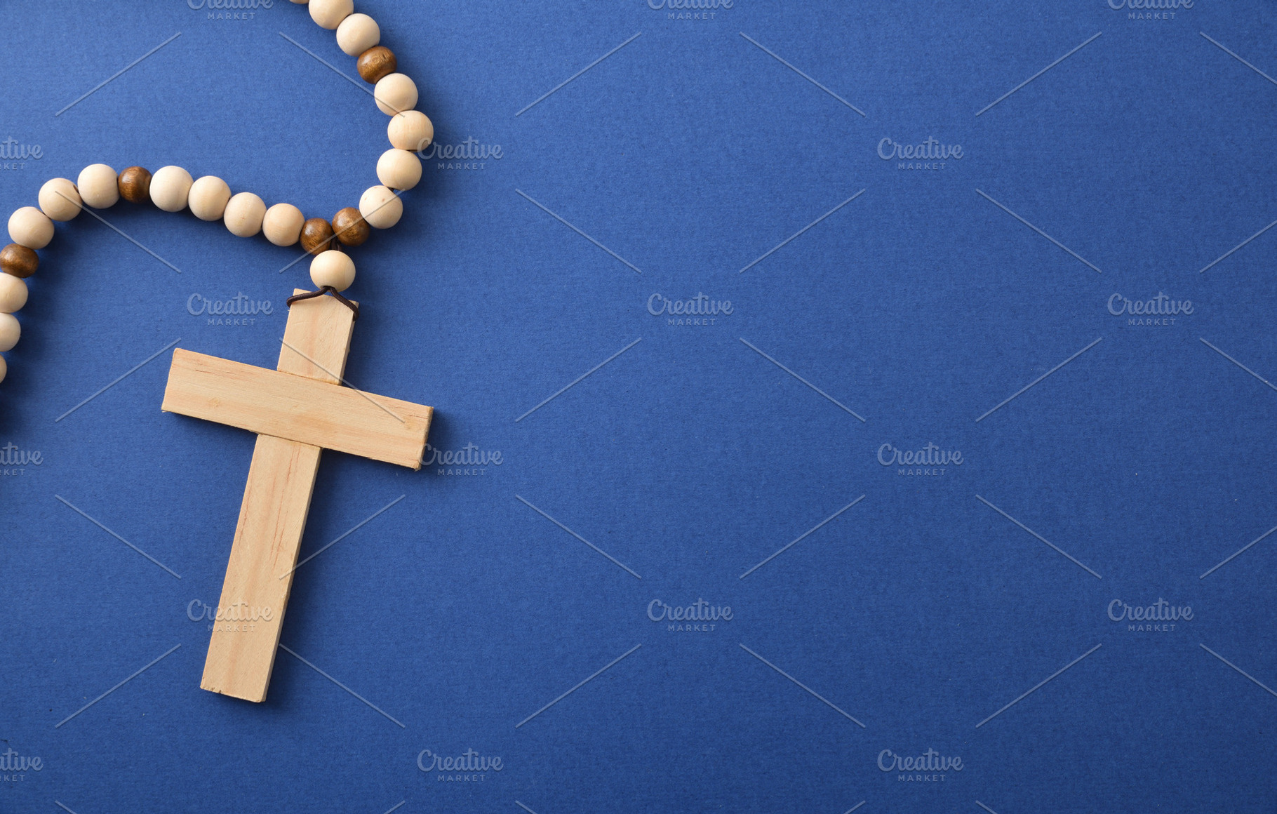 Wooden Cross Necklace on Blue Background, a Holiday Photo by Davizro's Market