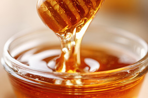 Honey jar with wooden dipper dripping honey, a Food & Drink Photo by AlyaAnd
