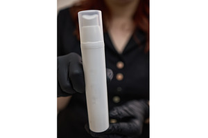 Serum bottle held by gloved hand, a Beauty & Fashion Photo by wip3out