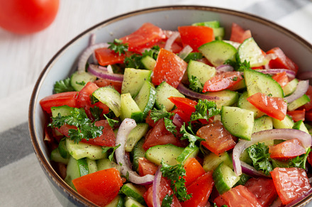 Homemade Mediterranean Cucumber Tomato Salad in a Bowl, side vie, a Food & Drink Photo by LiudmylaChuhunova