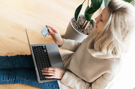 Young woman holding credit card and using laptop computer., a Person Photo by Olena Rudo