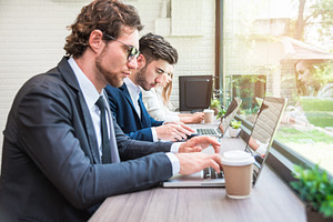Group of business people working with modern laptops in office.