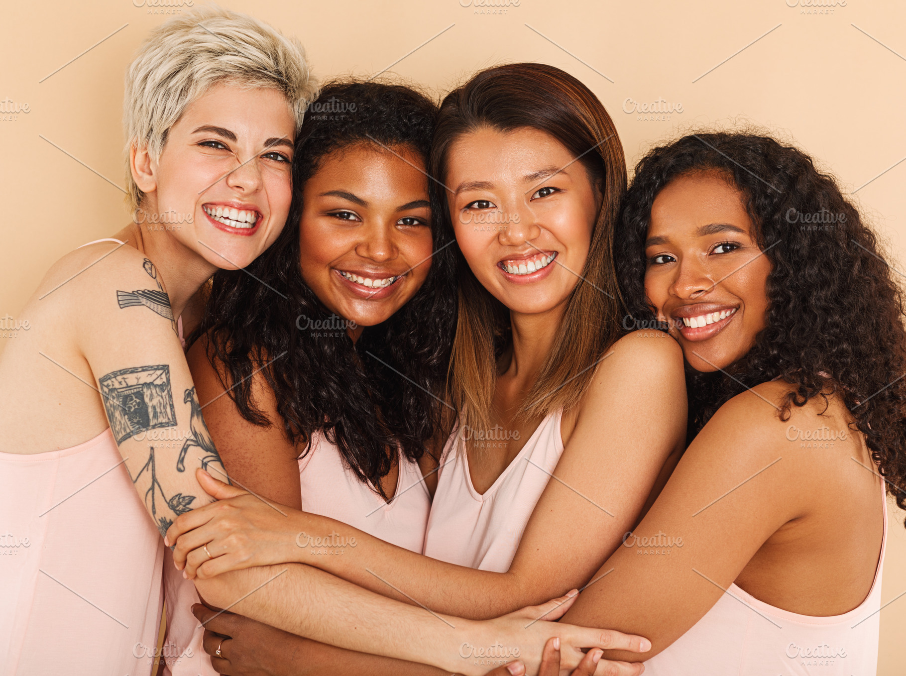 Four smiling diverse women embracing, a Person Photo by Artem Varnitsin