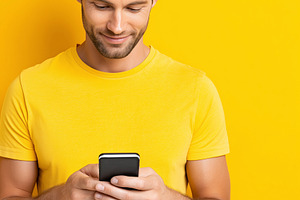 Smiling young man in a yellow shirt, a Technology Photo by MistyDay