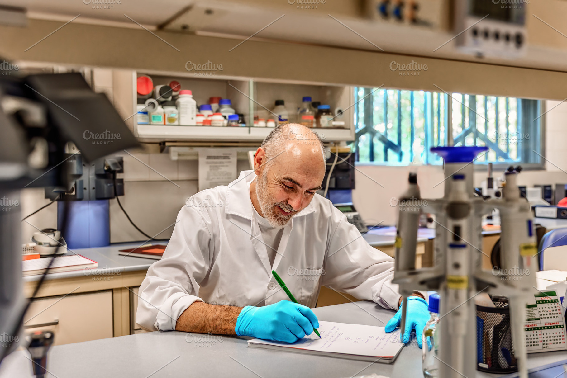 Smiling scientist writing in a labor, a Health & Medical Photo by Perpis