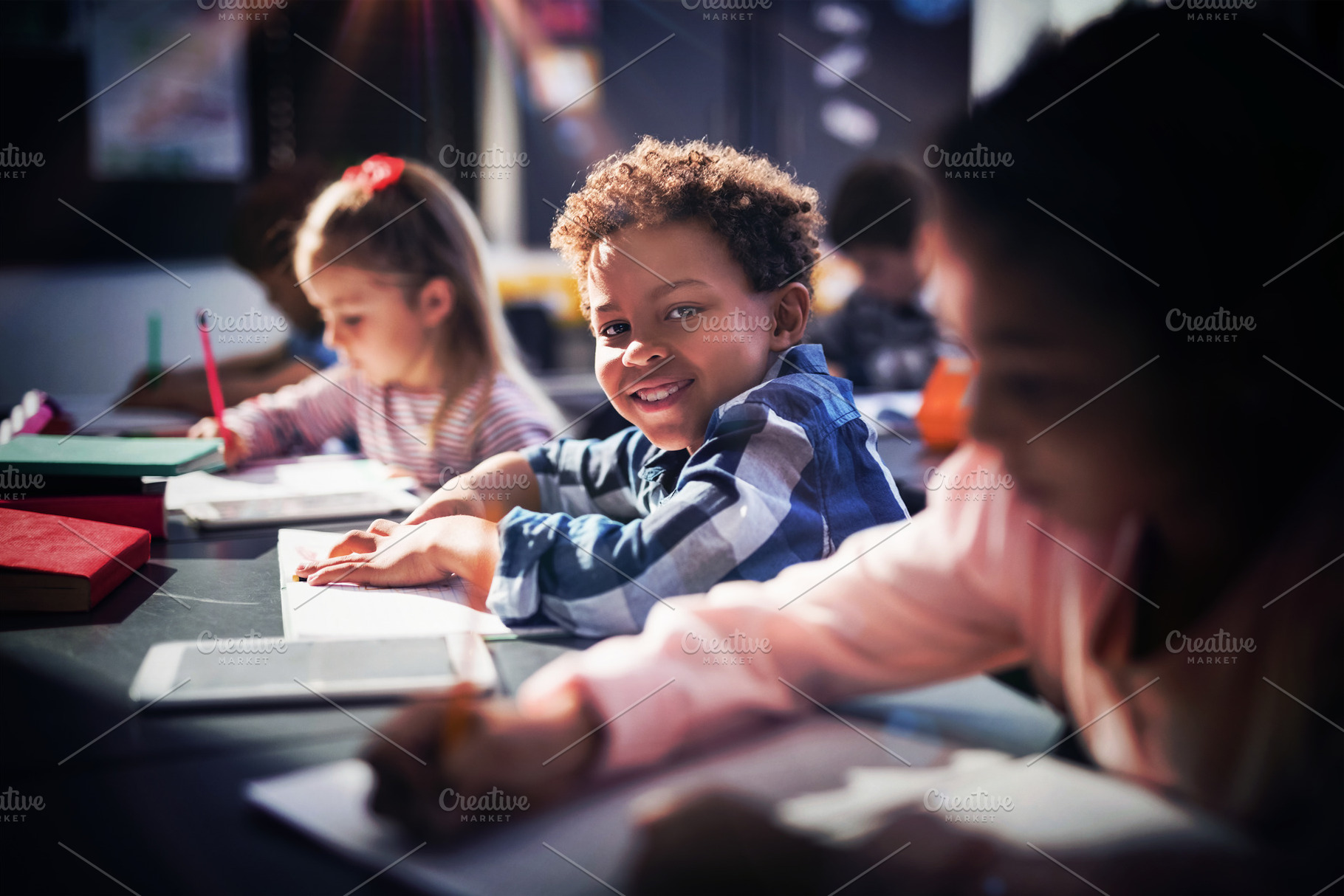 Smiling schoolboy doing his homework, a Photo by wavebreak
